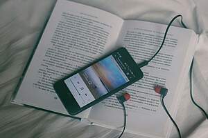 Book, smartphone and headphones
